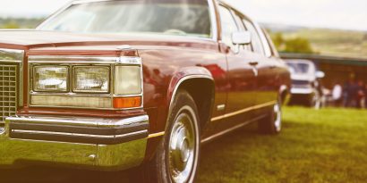 Retro car parked on grass. Film effect filter