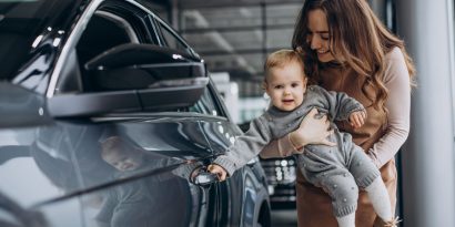 Mother with her baby daughter in a car showroom