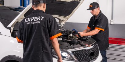 Mecânicos realizando diagnóstico de ruído no motor com suspeita de tucho batendo.